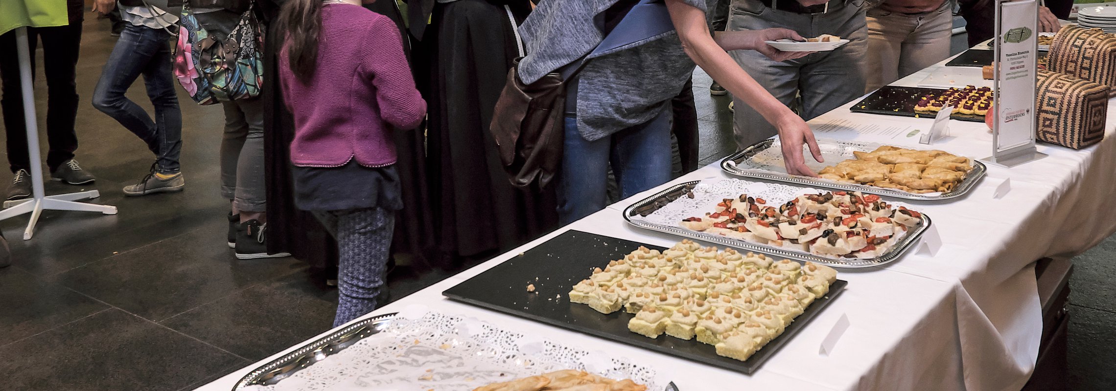 Menschen bedienen sich bei Fingerfood Buffet