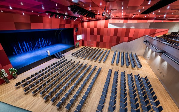 Großer Saal mit Kinobestuhlung und Bühne, Blick von oben.