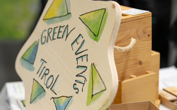 Green Events Tirol Logo auf Holzplatte