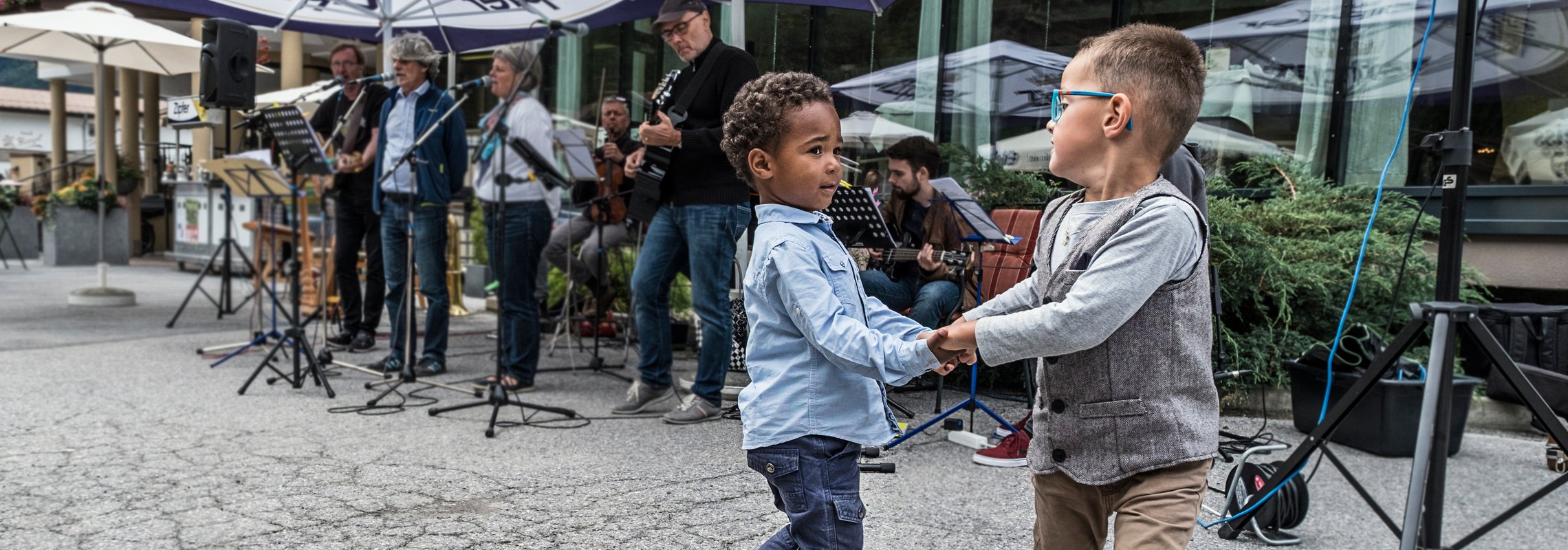 Tanzende Kinder vor einer Musikkapelle