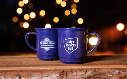 Zwei blaue Porzellantassen mit dem Logo von Alpbachtal Tourismus