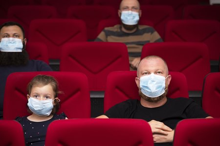 Tochter und Vater mit Mund Nasen Schutz im Theater