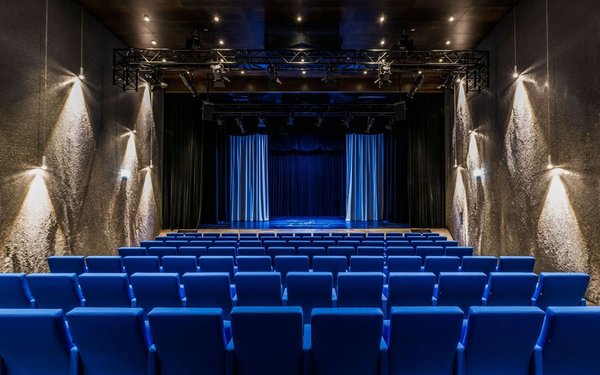 Theater mit Reihenbestuhlung, Blick von hinten im Saal auf die Bühne