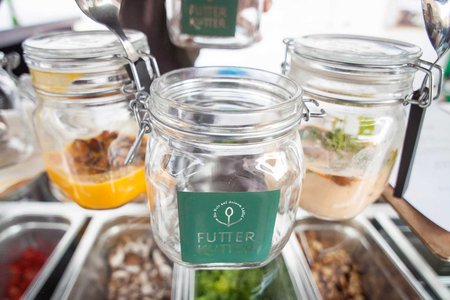 Ein Koch reicht ein Einmachglas mit Essen